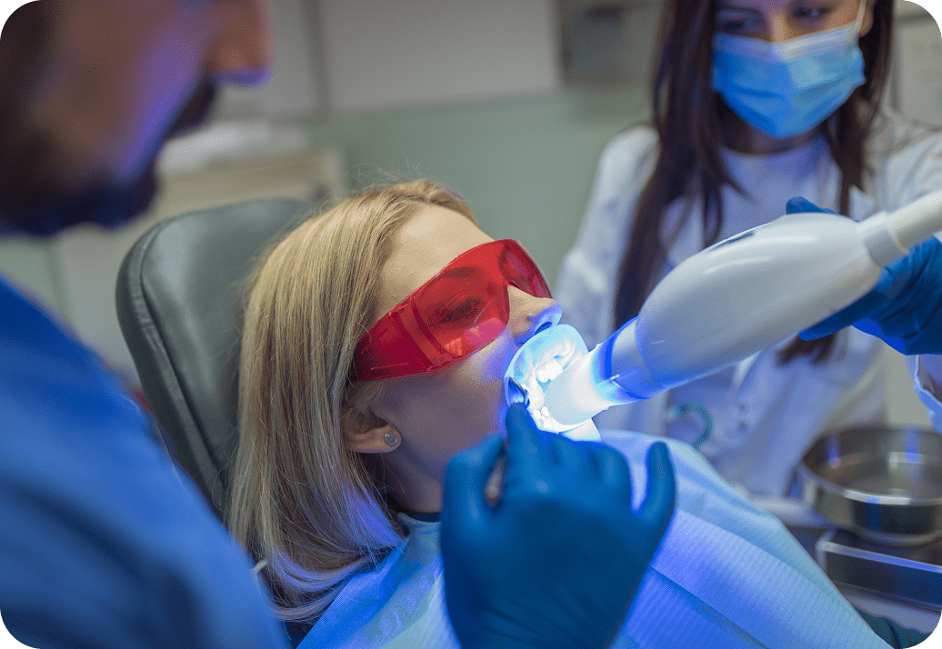 Dentist performing laser teeth whitening
